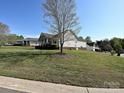 A well maintained side yard is presented with a sprawling lawn and neatly placed landscaping at 1009 Preston Dr, Lowell, NC 28098
