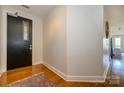 Clean, well-lit hallway with hardwood floors and a black door with glass, providing a welcoming entrance at 1101 W 1St St # 405, Charlotte, NC 28202