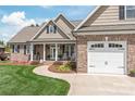 Inviting brick home with covered front porch and beautiful landscaping at 115 Ladybug Ct, Statesville, NC 28625