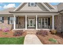 Charming front porch with brick columns and rocking chairs at 115 Ladybug Ct, Statesville, NC 28625