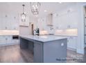 Spacious kitchen features white cabinets, stainless steel appliances, and large gray island with bar seating at 122 Huntcliff Dr, Statesville, NC 28677