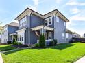 Stylish two-story home featuring attractive architectural details, a well-kept lawn, and a welcoming front porch at 13702 Jacks Ln, Pineville, NC 28134