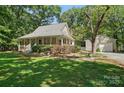 A charming home with a welcoming front porch and detached garage, nestled in a lush green setting at 13916 & 13912 Sledge Rd, Charlotte, NC 28278