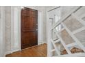Light-filled foyer showcasing a wooden front door, stylish wallpaper, and staircase with decorative railings at 13916 & 13912 Sledge Rd, Charlotte, NC 28278