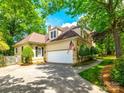 Home featuring an attached garage and driveway, surrounded by lush greenery on a sunny day at 15618 Eagleview Dr, Charlotte, NC 28278