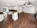Open-concept living space showcasing hardwood floors, white walls, and modern lighting fixtures at 1625 Winthrop Ln, Monroe, NC 28110