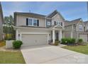 Inviting two-story home features a spacious driveway, attached garage, and a cozy front porch with manicured landscaping at 2014 Burton Point Ct, Waxhaw, NC 28173