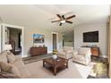 Staged living room with hardwood floors, neutral paint, a ceiling fan, and modern decor at 202 Hickory St, Locust, NC 28097