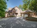 Inviting brick home featuring an attached two-car garage and a wide driveway at 209 Tinkham Trl, Cramerton, NC 28032