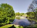 Scenic golf course view with a pond and lush green landscaping at 209 Tinkham Trl, Cramerton, NC 28032
