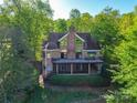 Stunning brick house with screened porch, deck, and lush greenery at 209 Tinkham Trl, Cramerton, NC 28032