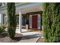 Welcoming front entrance with a red door, stone accents, and decorative shrubbery, perfect curb appeal at 2380 Fairport Se Dr, Concord, NC 28025