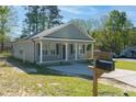 Single-story home featuring gray siding, black shutters, green lawn, and covered porch at 402 Digh St, Gastonia, NC 28052