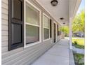 Relaxing front porch with classic columns and neutral-tone siding, offering a shaded outdoor space at 402 Digh St, Gastonia, NC 28052