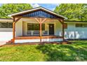 Inviting front porch with wooden beams, seating, and a view of the yard at 4110 Charles Raper Jonas Hwy, Alexis, NC 28006