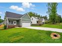 Exterior view of a green home showcasing its well-manicured lawn, two-car garage, and new construction neighborhood at 424 Fulton Dr, Kings Mountain, NC 28086