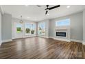 Open-concept living room featuring a fireplace, large windows, and modern ceiling fan at 424 Fulton Dr, Kings Mountain, NC 28086