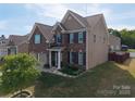 Brick and siding house boasts a well-maintained yard with green grass, mature trees, and an attached two-car garage at 4607 Bonroi Ave, Charlotte, NC 28213