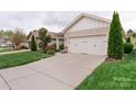 Charming home featuring a two-car garage, well-manicured lawn, and beautiful landscaping at 4991 Looking Glass Trl, Denver, NC 28037