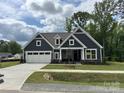 Charming new construction home featuring a well-manicured lawn and a spacious white two-car garage at 5006 Mclaughlin Dr # 103, Waxhaw, NC 28173