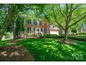 Charming two-story brick home with a well-manicured lawn and mature trees at 511 Pembroke Ln, Waxhaw, NC 28173