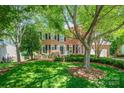 Charming two-story brick home with a well-manicured lawn and mature trees at 511 Pembroke Ln, Waxhaw, NC 28173