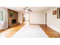 Bright living room with a stone fireplace, hardwood floors, and a ceiling fan at 542 9Th Nw St, Hickory, NC 28601