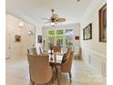 Bright dining room features a large window, elegant lighting, and a classic table with seating for six at 6133 Wakehurst Rd, Charlotte, NC 28226