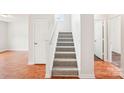 Carpeted staircase with white banister connecting multiple levels in a well-lit home at 759 Victory Gallop Ave, Clover, SC 29710