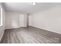 Spacious living room featuring modern light gray walls, base molding, and durable gray wood-look vinyl flooring at 816 Echo Glen Rd, Charlotte, NC 28213