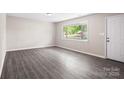 Inviting living room with bright natural light, gray laminate flooring, and freshly painted light gray walls at 816 Echo Glen Rd, Charlotte, NC 28213