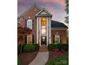 Stately red brick home featuring a grand two-story entrance with white pillars and manicured landscaping at 9217 Rock Water Ct, Waxhaw, NC 28173