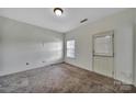 Bedroom featuring carpeted floors, a window, and an exterior door at 9862 Walkers Glen Nw Dr, Concord, NC 28027