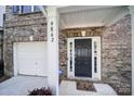Close-up of the front door, garage, and house numbers at 9862 Walkers Glen Nw Dr, Concord, NC 28027