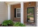 Inviting front porch with brick accents, decorative columns, and a glass front door at 1004 Toquima Trl, Monroe, NC 28110
