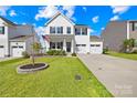 Charming two-story home with a well-manicured lawn, mature tree, and a two-car garage at 109 Fairfield Dr, Troutman, NC 28166