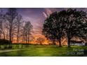 Scenic sunset over green property with mature trees and farm buildings at 153 Coachman Loop, Statesville, NC 28625