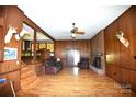 Cozy living room with hardwood floors, fireplace and wood-paneled walls at 17389 Mooresville Rd, Mooresville, NC 28115