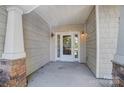 Inviting front porch featuring stone accents, shingle siding, and decorative sconce lighting providing a warm welcome at 2113 London Ln, Belmont, NC 28012