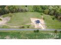 An aerial view shows a modern home on a large lot with a long driveway and surrounding trees at 2133 Tite Rd, Stanfield, NC 28163