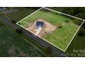 An aerial view of a gray two-story home on a large green lot with a long driveway at 2133 Tite Rd, Stanfield, NC 28163