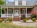 Inviting front porch with white railing, brick accents, and a decorative wreath on the front door at 3179 Westview Rd, Concord, NC 28025