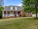Lovely brick home with a cozy front porch, lush green lawn, and manicured landscaping at 3179 Westview Rd, Concord, NC 28025