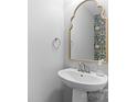 Stylish powder room featuring a pedestal sink, ornate mirror, and designer wallpaper accent at 3245 Major Samuals Way, Charlotte, NC 28208