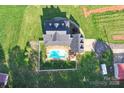 Aerial view showcasing the home's backyard with a fenced in pool, lush lawn, and surrounding greenery at 3300 Paul Heavner Ln, Lincolnton, NC 28092