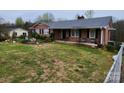 One-story brick home featuring an inviting front porch, surrounded by green lawn and partial landscaping at 406 S Caldwell Ave, Newton, NC 28658