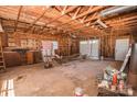 Unfinished garage interior with exposed wood ceiling, concrete floor, and garage door at 451 S Strand Dr, Norwood, NC 28128