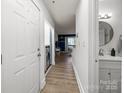 Hallway view including bathroom and laundry nook; features modern lighting and wood-look flooring at 505 N Graham St # 2H, Charlotte, NC 28202