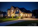 Elegant two-story brick home with a three-car garage, a well-manicured lawn and beautiful landscaping at 5051 Hyannis Ct, Matthews, NC 28104