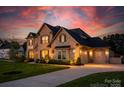 Elegant two-story brick home with a three-car garage, and a beautifully landscaped yard at 5051 Hyannis Ct, Matthews, NC 28104